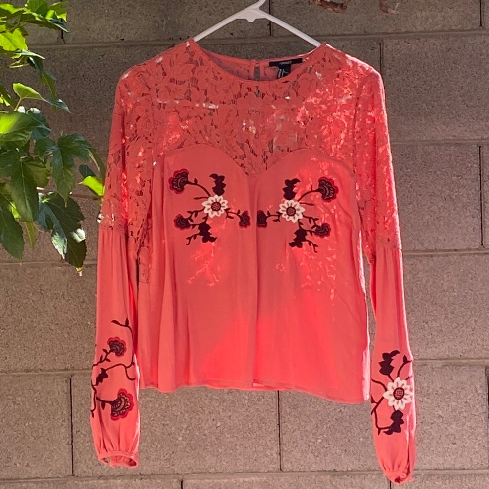 Pink blouse with embroidered details.